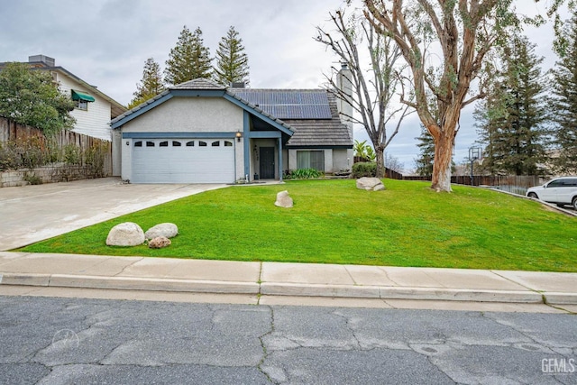 view of front of property with concrete driveway, a front yard, roof mounted solar panels, stucco siding, and a garage