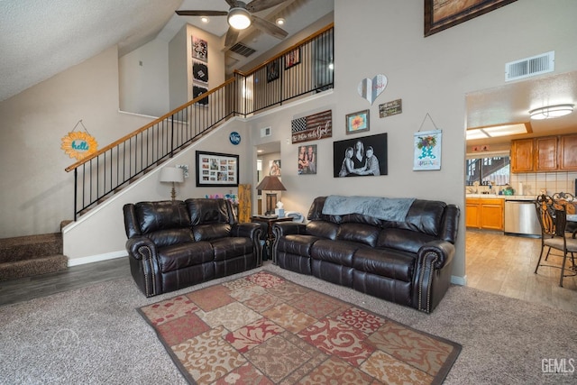 living room featuring ceiling fan, hardwood / wood-style floors, and a high ceiling