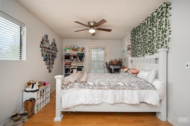 bedroom with ceiling fan, wood-type flooring, and a textured ceiling