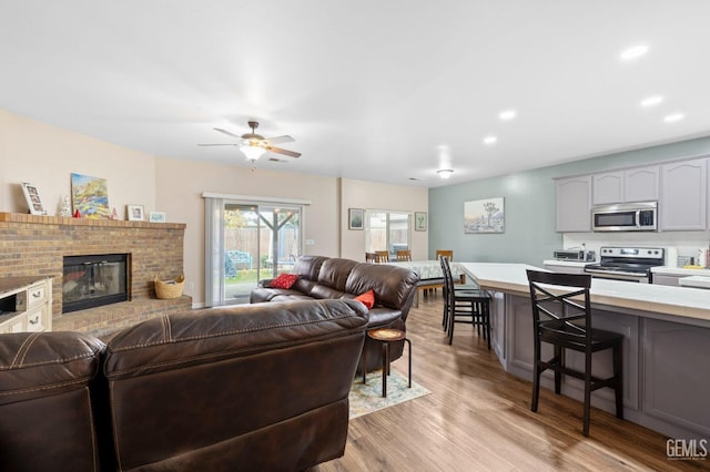 7303 Glenn Miller Ct, Bakersfield, CA 93312 - living room featuring a fireplace, recessed lighting, light wood-style flooring, and ceiling fan