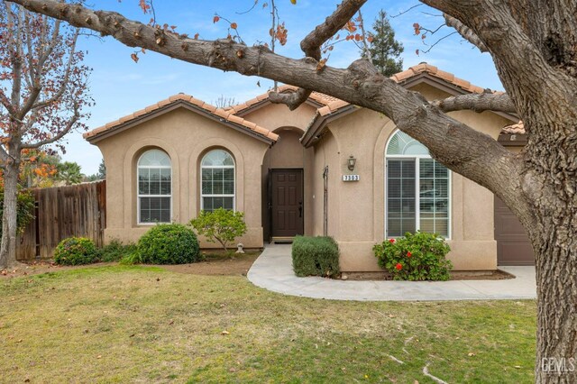 7303 Glenn Miller Ct, Bakersfield, CA 93312 - mediterranean / spanish home with a front yard, a tile roof, fence, and stucco siding