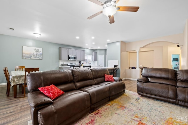 7303 Glenn Miller Ct, Bakersfield, CA 93312 - living area with visible vents, arched walkways, ceiling fan, ornate columns, and wood finished floors