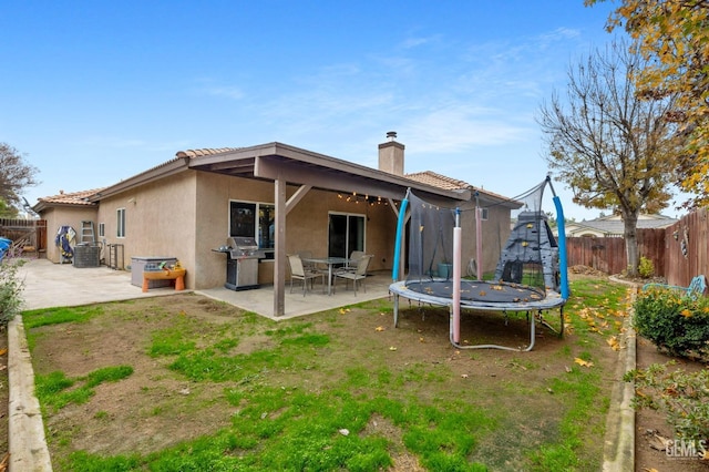 7303 Glenn Miller Ct, Bakersfield, CA 93312 - rear view of property featuring a patio, a trampoline, a fenced backyard, and stucco siding