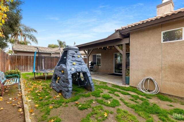7303 Glenn Miller Ct, Bakersfield, CA 93312 - view of yard featuring a trampoline, a patio area, a fenced backyard, and a ceiling fan