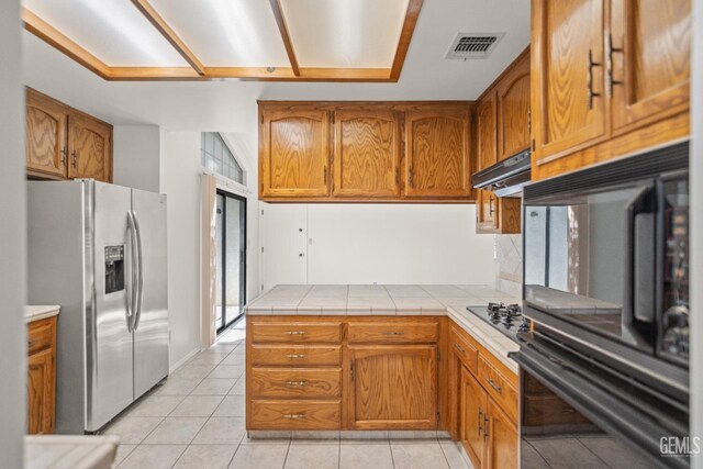 7205 Bandolero Way, Bakersfield, CA 93308 - kitchen with stainless steel fridge with ice dispenser, brown cabinetry, and under cabinet range hood