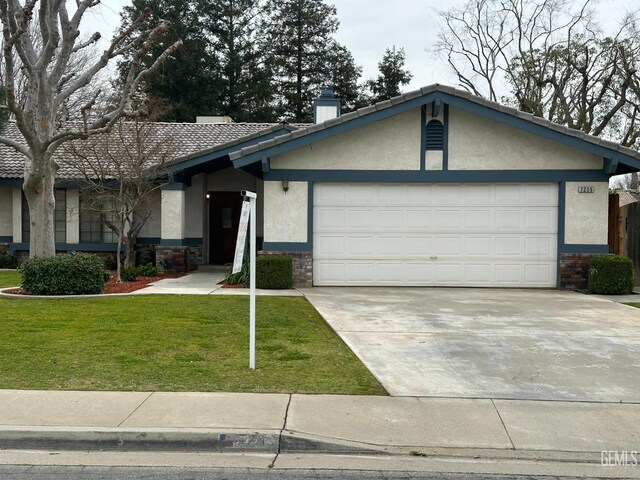 ranch-style house featuring a garage and a front lawn