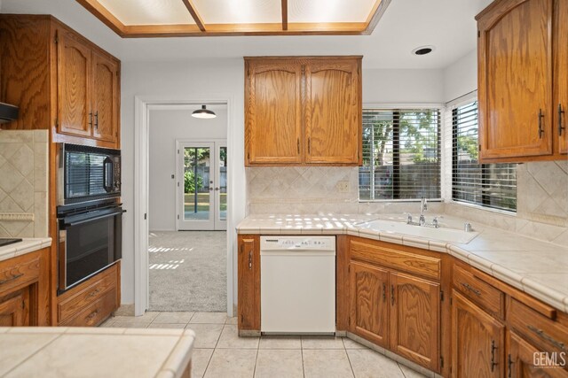 7205 Bandolero Way, Bakersfield, CA 93308 - kitchen with black appliances, plenty of natural light, light tile patterned floors, and backsplash