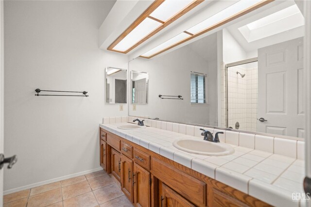 7205 Bandolero Way, Bakersfield, CA 93308 - full bath featuring a skylight, a shower stall, double vanity, baseboards, and tile patterned floors