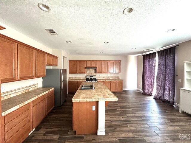10315 Paradiso Way, Bakersfield, CA 93306 - kitchen with stainless steel appliances, a sink, dark wood-style flooring, recessed lighting, and a kitchen island with sink