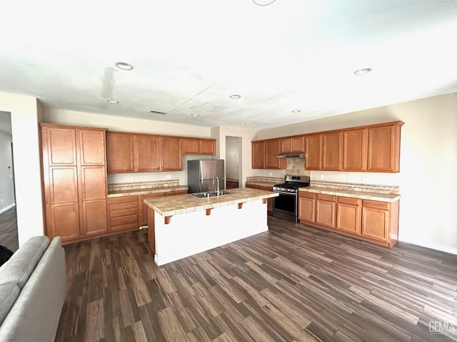 10315 Paradiso Way, Bakersfield, CA 93306 - kitchen with stainless steel appliances, a sink, under cabinet range hood, light countertops, and dark wood-type flooring