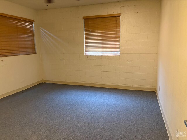 267 Cedar Ave, Earlimart, CA 93219 - empty room with concrete block wall, carpet floors, and ceiling fan