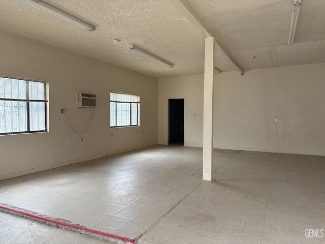 267 Cedar Ave, Earlimart, CA 93219 - unfurnished room featuring a textured ceiling, a wall mounted air conditioner, and light floors