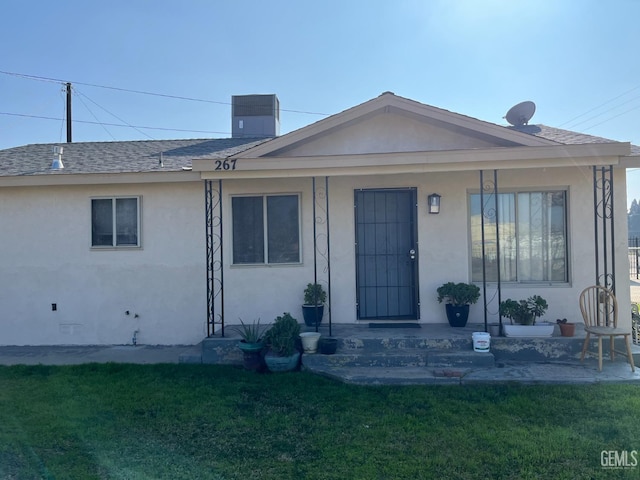 267 Cedar Ave, Earlimart, CA 93219 - view of front facade with a shingled roof, stucco siding, a porch, and a front yard