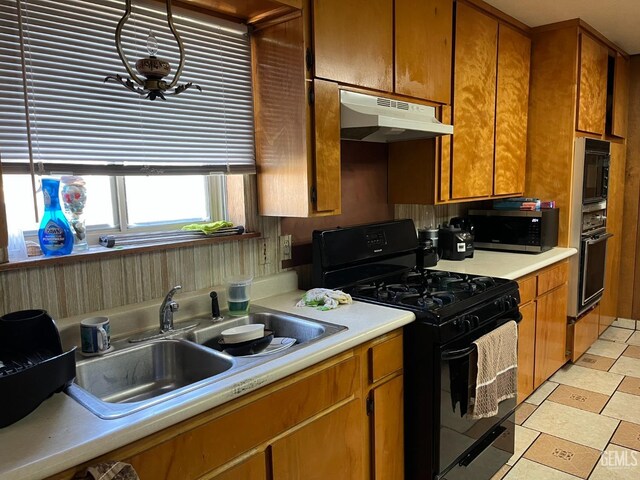 267 Cedar Ave, Earlimart, CA 93219 - kitchen with light countertops, under cabinet range hood, brown cabinets, a sink, and black appliances