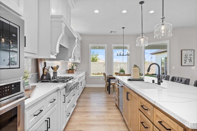 kitchen with stainless steel appliances, sink, white cabinets, decorative backsplash, and light brown cabinetry