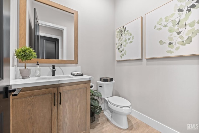 bathroom featuring toilet, wood-type flooring, and vanity