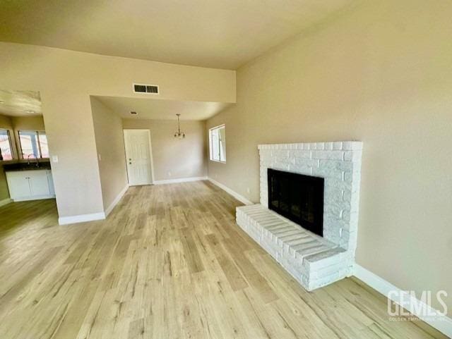 unfurnished living room featuring a wealth of natural light and light hardwood / wood-style floors