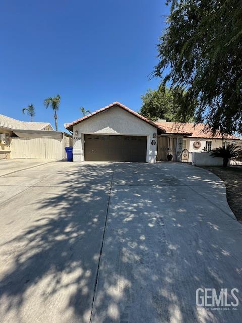 9306 Vista Colina Dr, Bakersfield, CA 93306 - view of front facade with driveway, an attached garage, stucco siding, and a tile roof