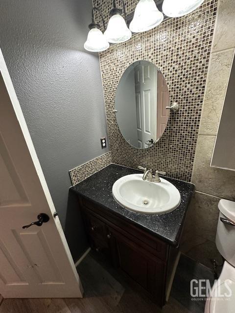 9306 Vista Colina Dr, Bakersfield, CA 93306 - half bathroom featuring vanity, tile walls, and tasteful backsplash