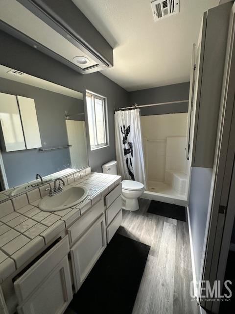 9306 Vista Colina Dr, Bakersfield, CA 93306 - bathroom featuring wood finished floors, a shower stall, and vanity