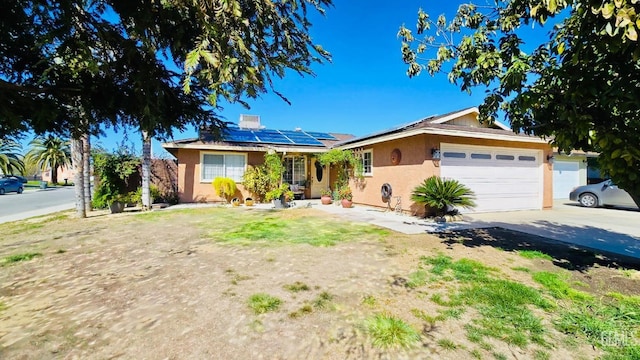 ranch-style home with solar panels, concrete driveway, an attached garage, and stucco siding