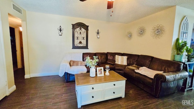 living area with visible vents, dark wood-type flooring, baseboards, a textured ceiling, and a ceiling fan