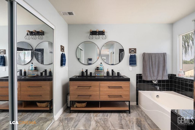 11703 Revolution Rd, Bakersfield, CA 93312 - bathroom with double vanity, a bath, and marble finish flooring