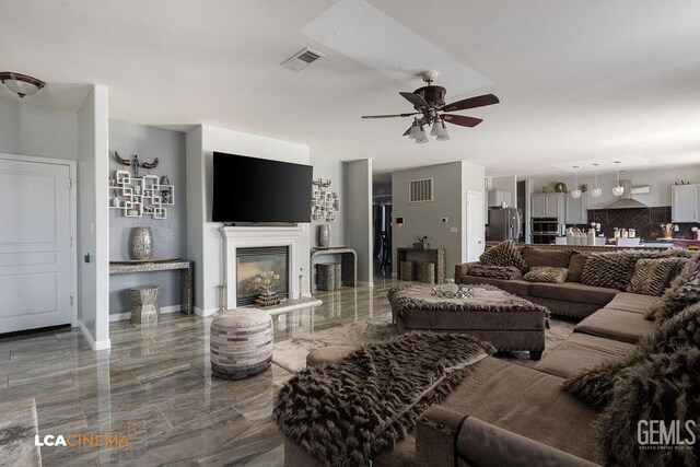 11703 Revolution Rd, Bakersfield, CA 93312 - living area featuring a ceiling fan, marble finish floors, and a glass covered fireplace