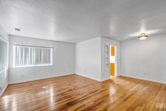 empty room with hardwood / wood-style flooring