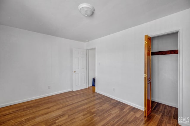 unfurnished bedroom featuring a closet and dark hardwood / wood-style floors