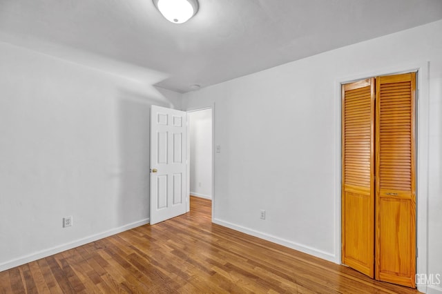 unfurnished bedroom featuring a closet and hardwood / wood-style floors