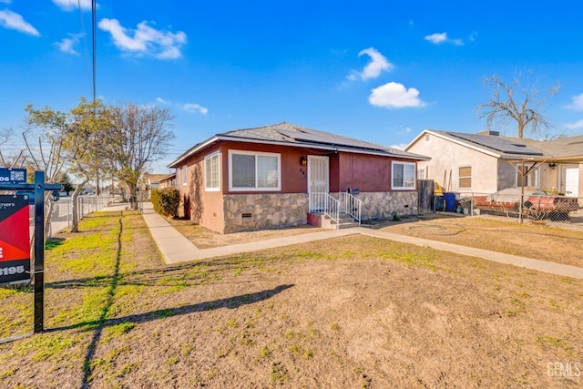 view of front of home featuring a front lawn and solar panels