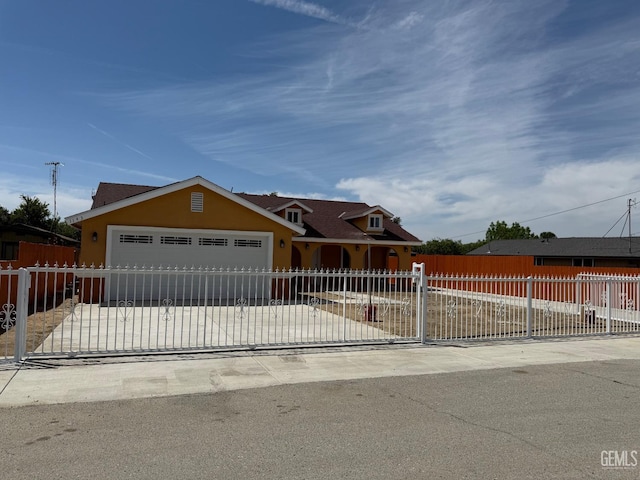 view of front of home featuring a garage, a fenced front yard, driveway, and stucco siding