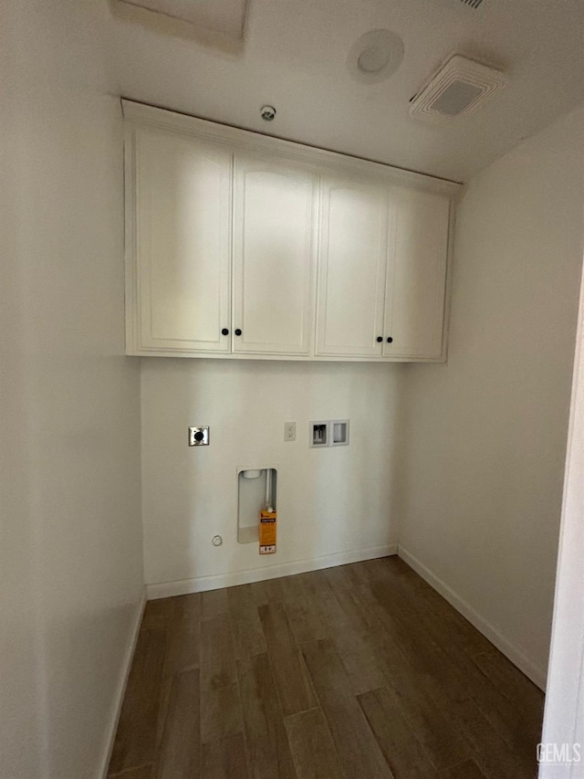 laundry area with electric dryer hookup, cabinet space, dark wood-type flooring, and baseboards