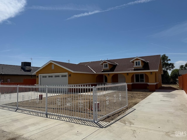view of front of house with a fenced front yard, a garage, central air condition unit, concrete driveway, and a shingled roof
