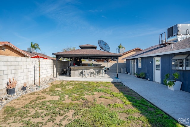 view of yard featuring a gazebo, a patio area, and exterior bar