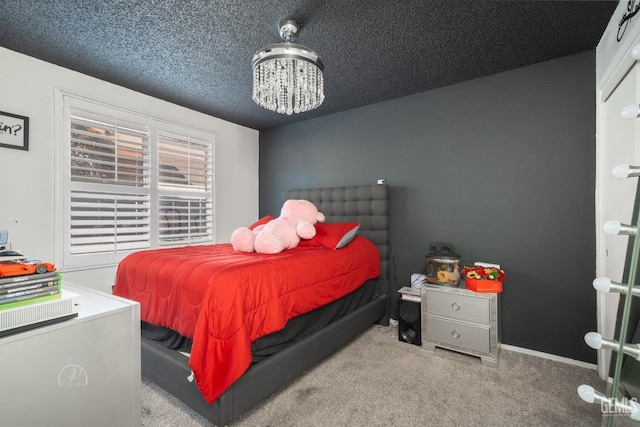 carpeted bedroom featuring a notable chandelier and a textured ceiling