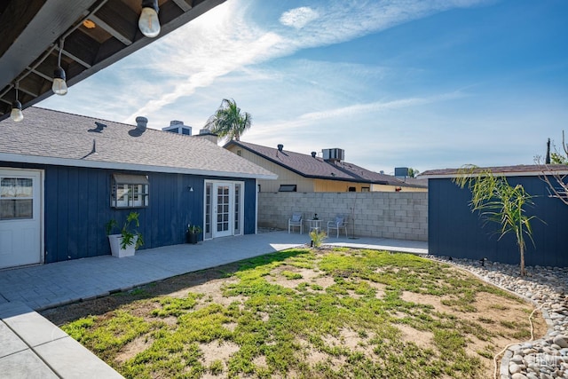 view of yard featuring central AC, a patio, and french doors