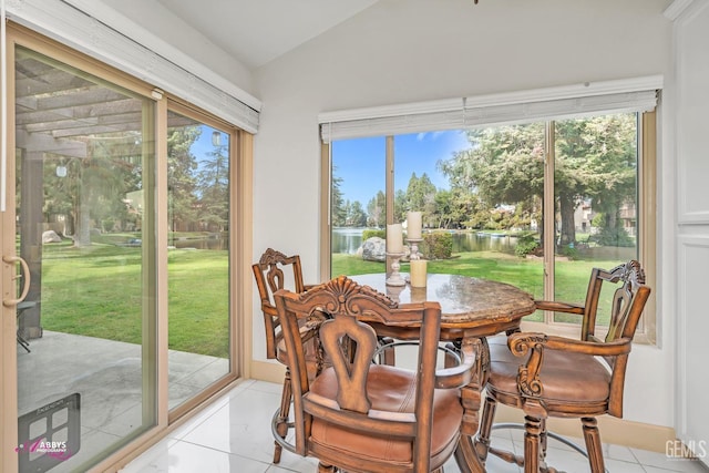 dining area with lofted ceiling and light tile patterned flooring