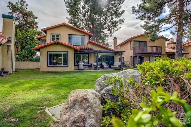 rear view of house with an outdoor hangout area, fence, a tiled roof, a lawn, and stucco siding