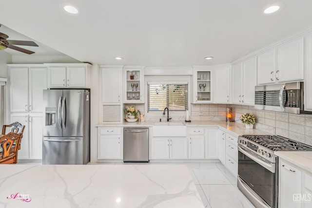 kitchen featuring stainless steel appliances, a sink, and white cabinets