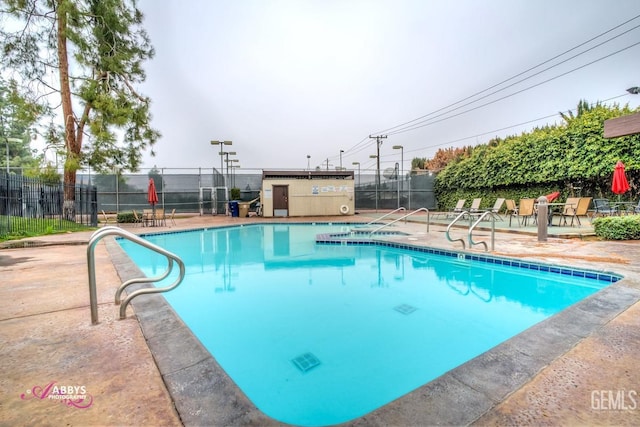 pool featuring fence and a patio