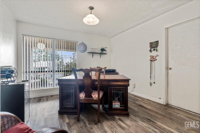 dining area with dark hardwood / wood-style floors and a textured ceiling