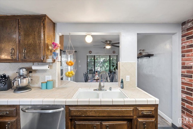 kitchen featuring dark brown cabinetry, sink, and tile countertops