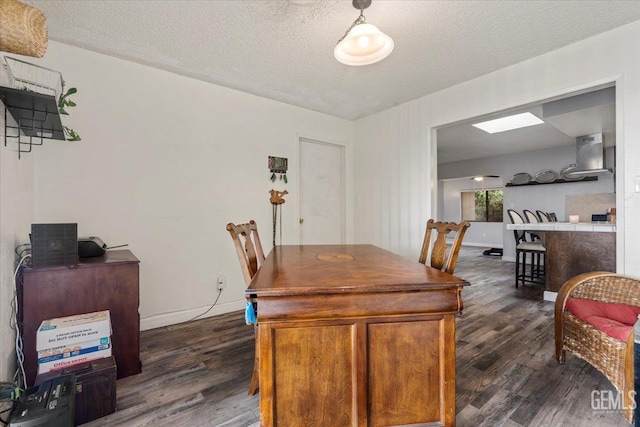 dining area featuring dark wood-type flooring and a textured ceiling