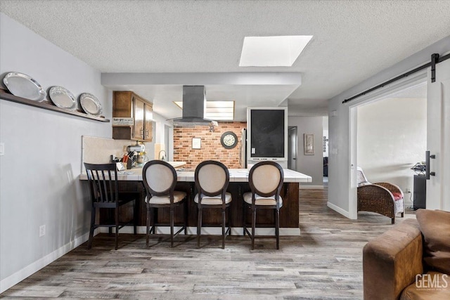 bar featuring light hardwood / wood-style floors, a textured ceiling, and island exhaust hood