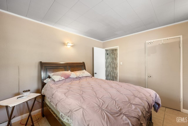bedroom with baseboards, tile patterned flooring, and crown molding