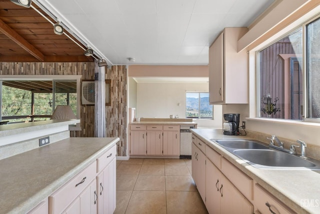 kitchen featuring light countertops, a sink, dishwasher, and light tile patterned flooring