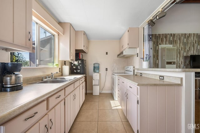 kitchen featuring a peninsula, electric range, light countertops, under cabinet range hood, and light tile patterned floors
