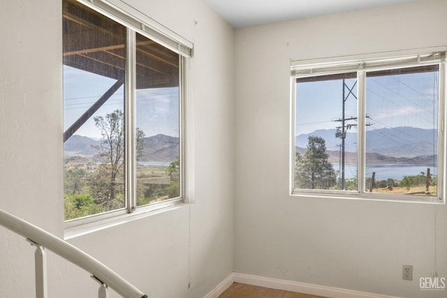 empty room with baseboards and a mountain view